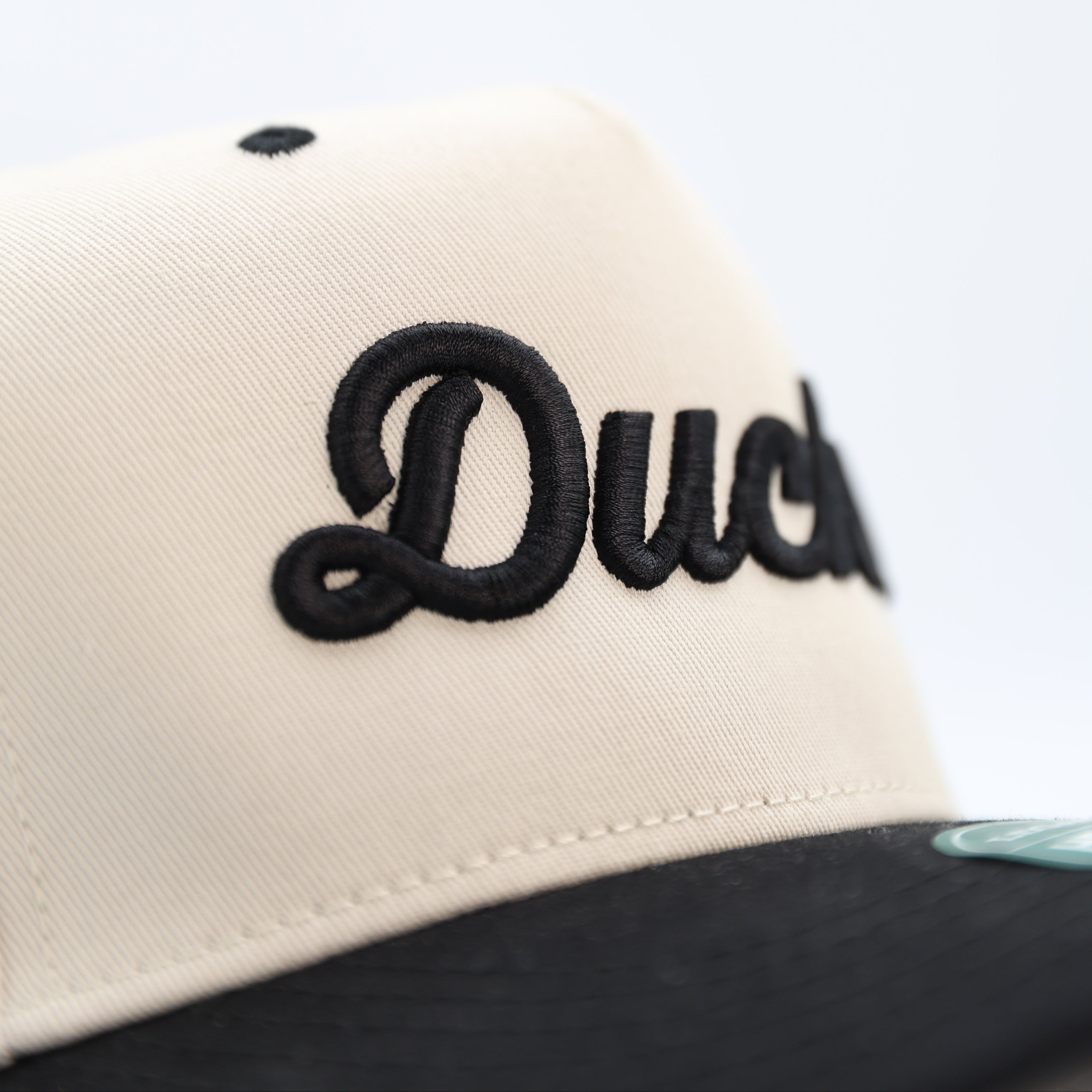 Close-up of a cap with black text on a beige background