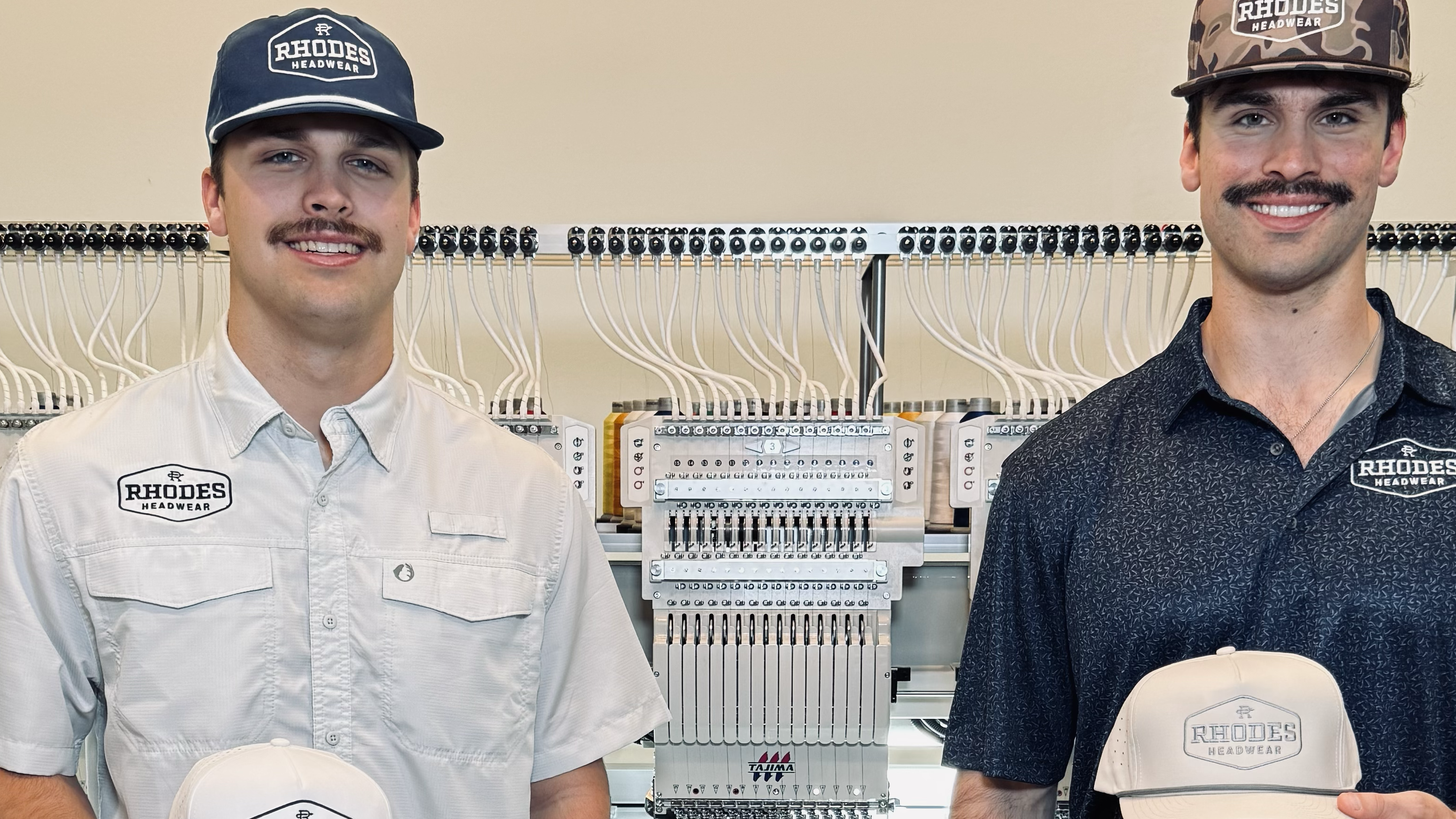 Two men holding hats in a workshop setting